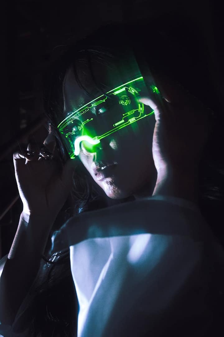 a woman wearing a green light up mask